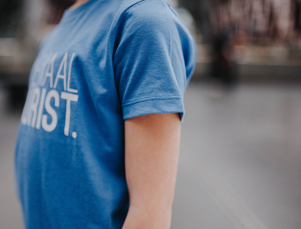 Close-up van de mouw van een blauwe T-shirt.