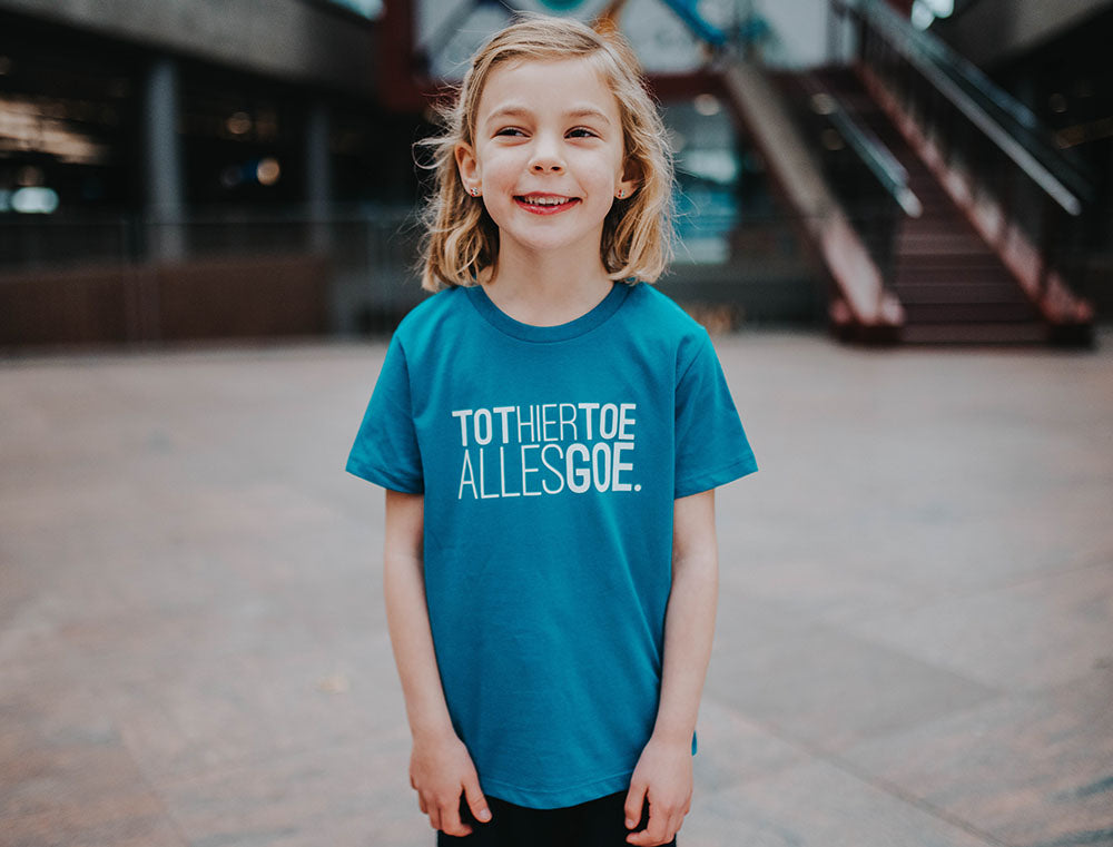 Meisje met blauwe T-shirt met opdruk TOTHIERTOEALLESGOE.