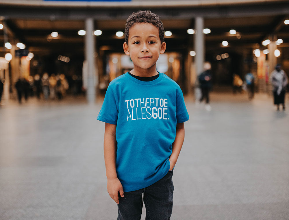 Jongen met blauwe T-shirt met opdruk TOTHIERTOEALLESGOE.