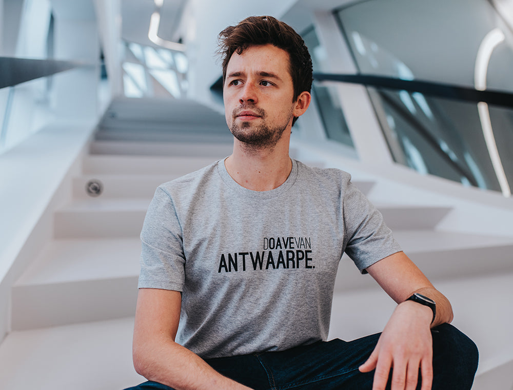 Man met grijze T-shirt met opschrift DOAVEVANANTWAARPE.