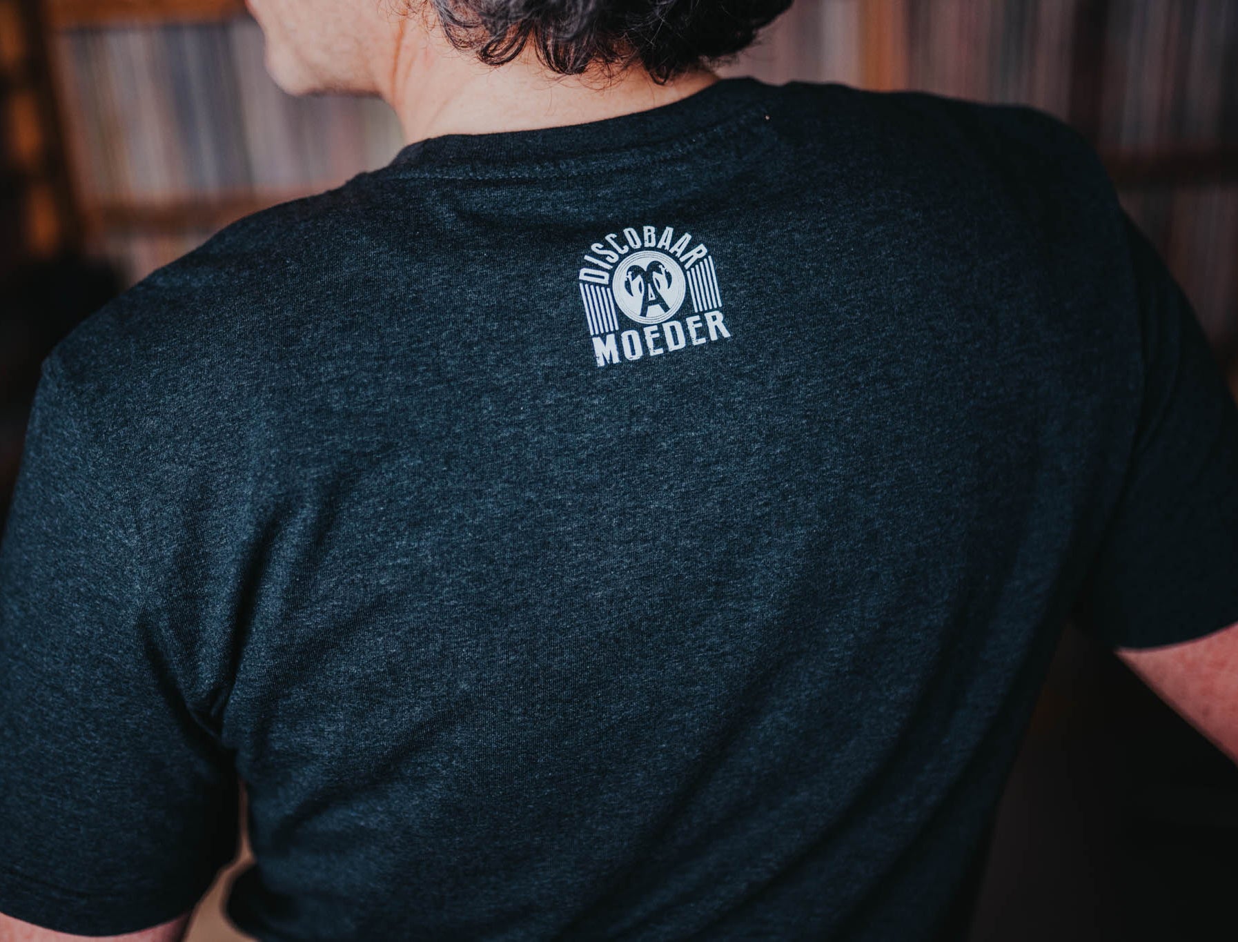 Close-up van het logo van Discobaar a moeder op een grijze T-shirt.