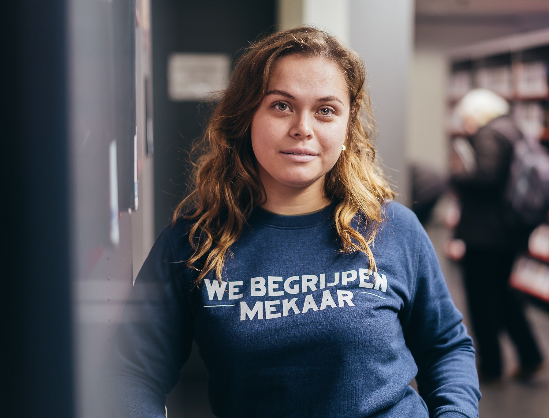 Vrouw met blauwe trui met opdruk we begrijpen mekaar.